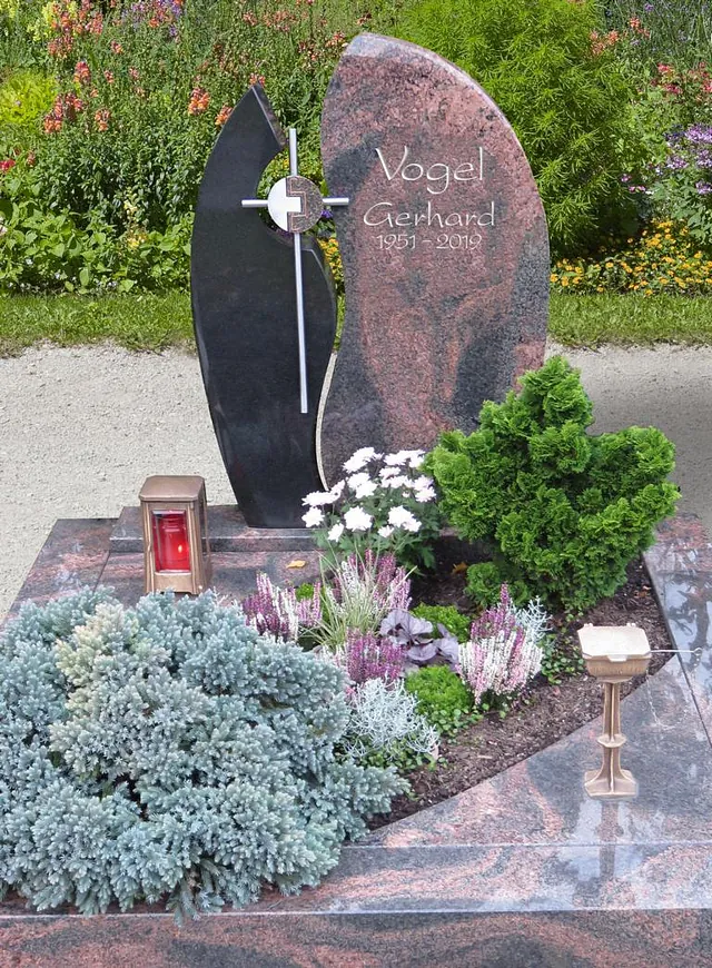 Denkmal mit Kreuz und Pflanzen