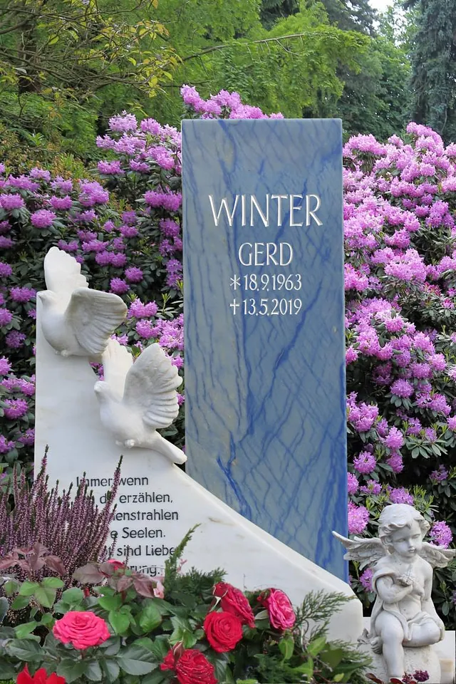 Denkmal mit blauen Akzenten und zwei Taubenfiguren im Vordergrund