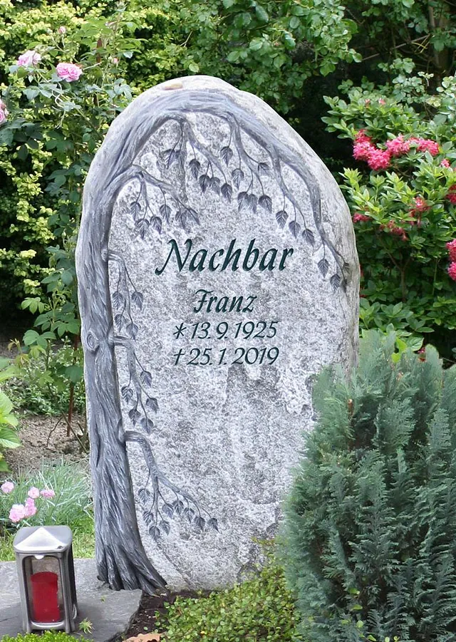 Tiefergelegtes Denkmal in Grau und hoher Bepflanzung