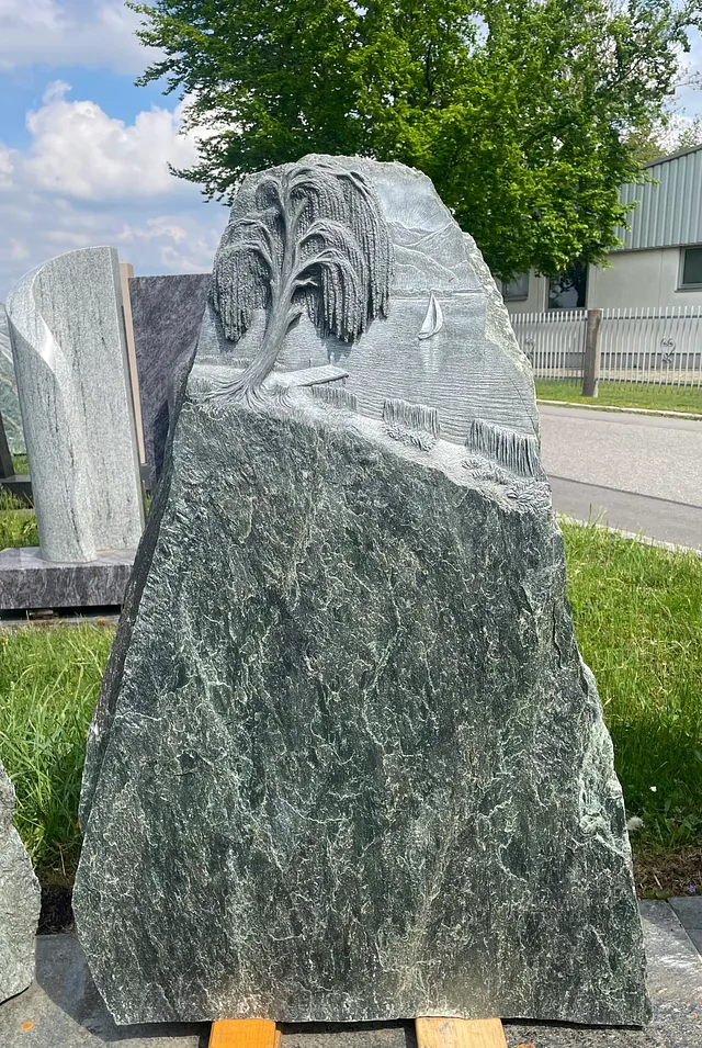 In Stein gemeißeltes Bild eines Baumes und einem See