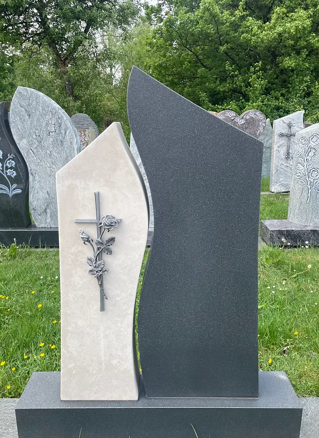 Denkmal mit einem Kreuz und Rosen