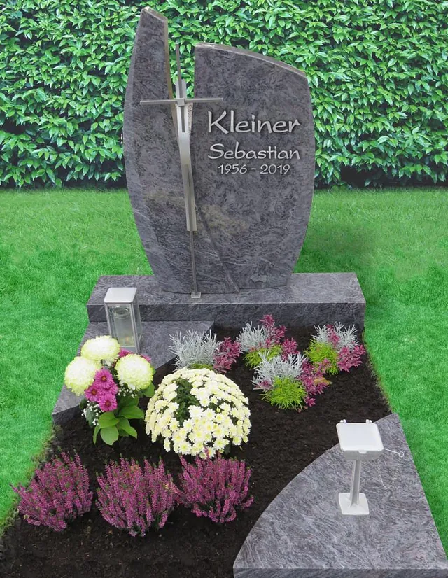 Tiefergelegtes Denkmal in Grau und einem Metallkreuz