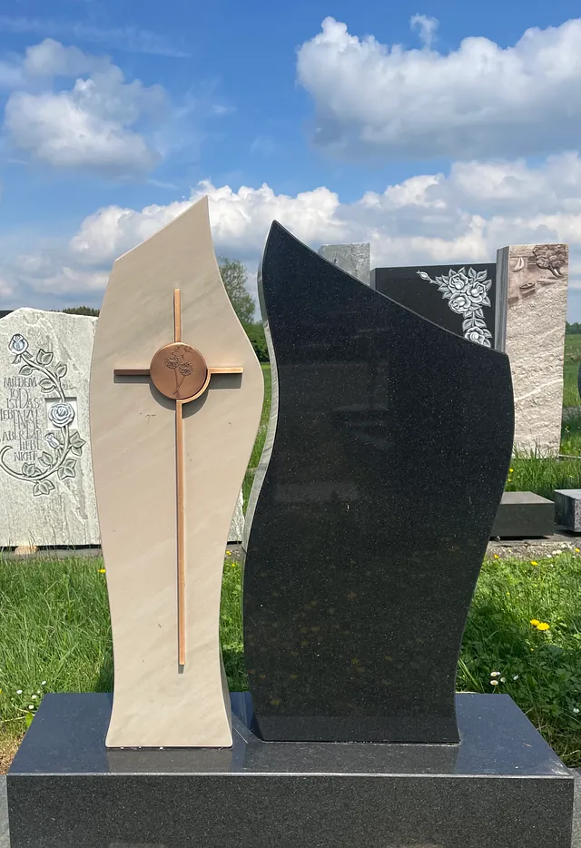 Beige und schwarzes Denkmal mit Kreuz