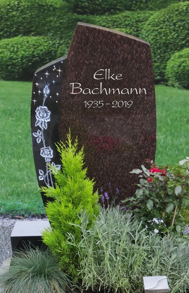 Braunes Denkmal mit Bepflanzung im Vordergrund